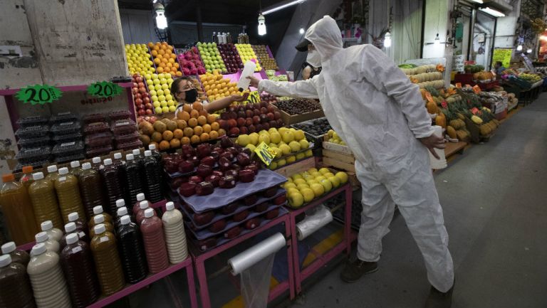 Trabajadora de la Central de Abastos recibe bote de alcohol 