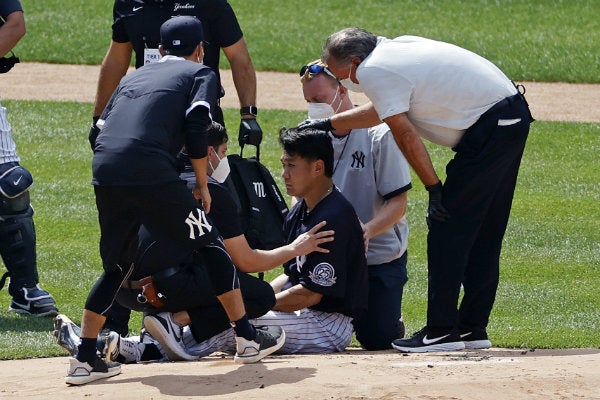 El abridor de los Yanquis Masahiro Tanaka, siendo atendido