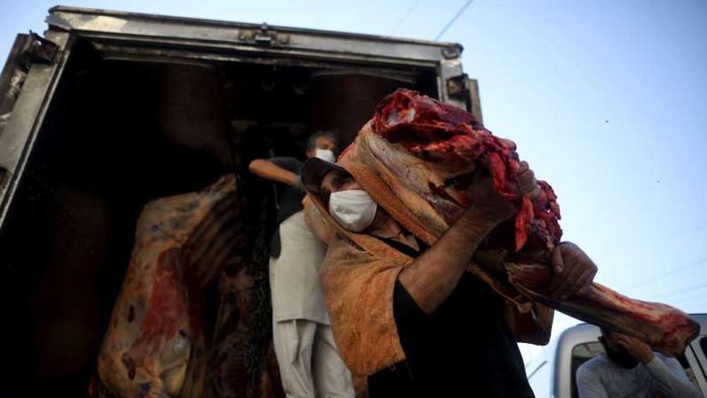 Un trabajador entrega una pieza de carne