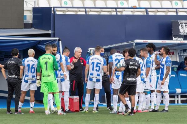 Aguirre platica con jugadores del Leganés en un partido