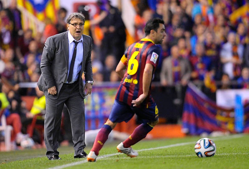 Tata Martino da indicaciones a Xavi durante un duelo del Barcelona