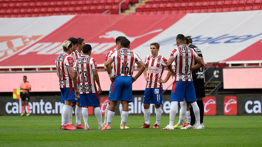 Jugadores de Chivas platican en el terreno de juego