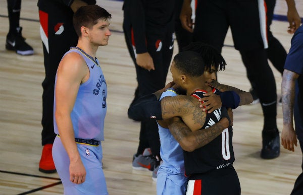 Ja Morant y Damian Lillard se abrazan