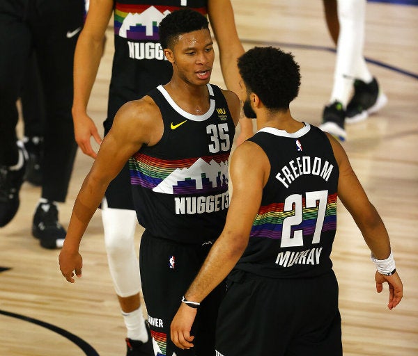 Jamal Murray (derecha) y PJ Dozier, de los Nuggets de Denver, festejan la victoria