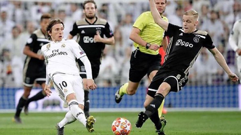 Van de Beek pelea un balón con Modric en la Champions 