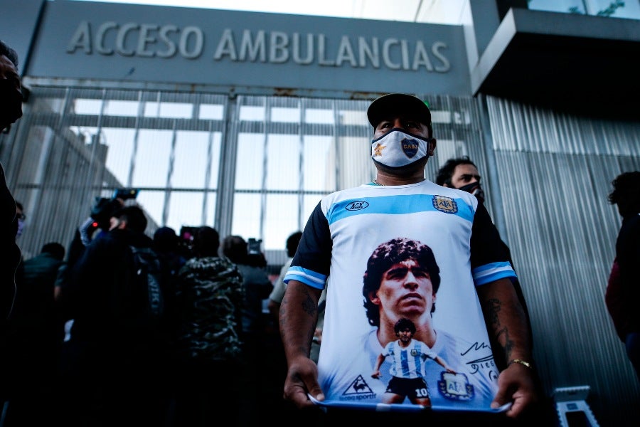 Un hombre apoyando a Maradona a las afueras del hospital