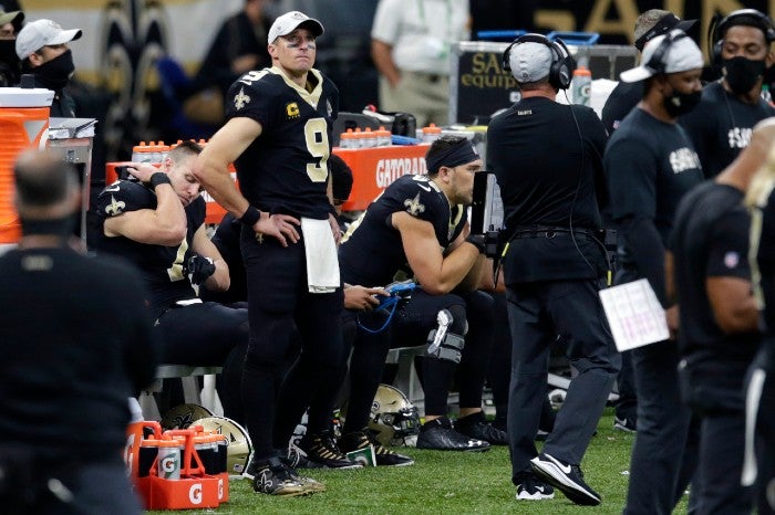 Brees observa el juego desde la banca