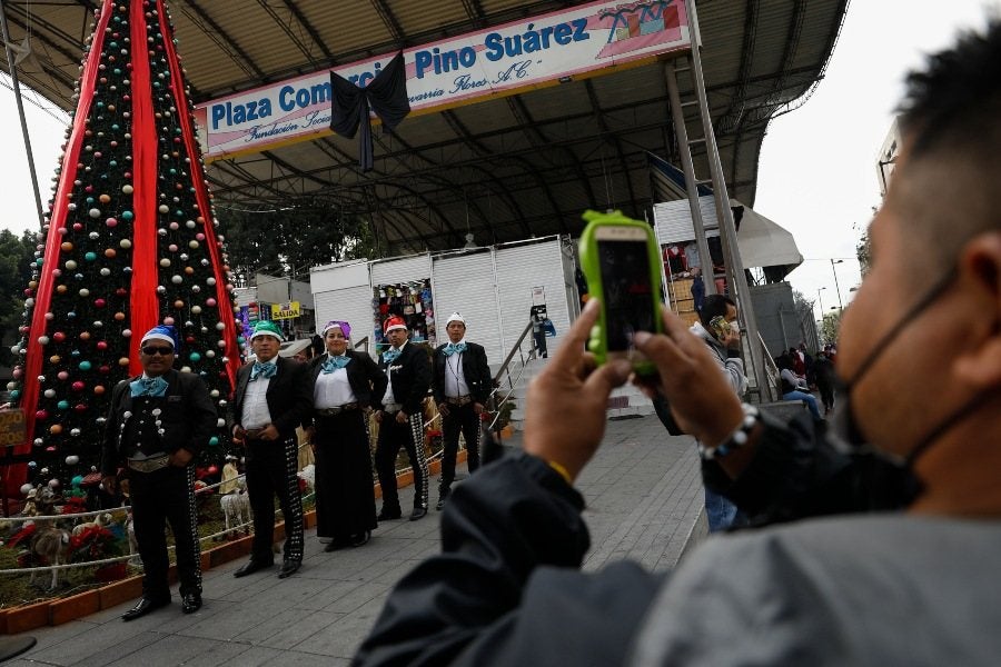 Grupo de mariachis junto a un árbol de Navidad