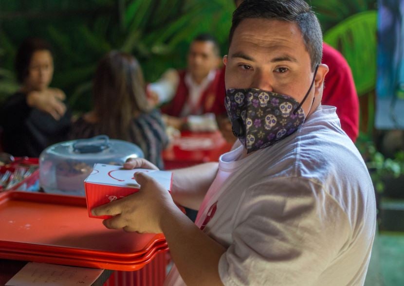 Trabajador con Síndrome de Down atiende su mesa