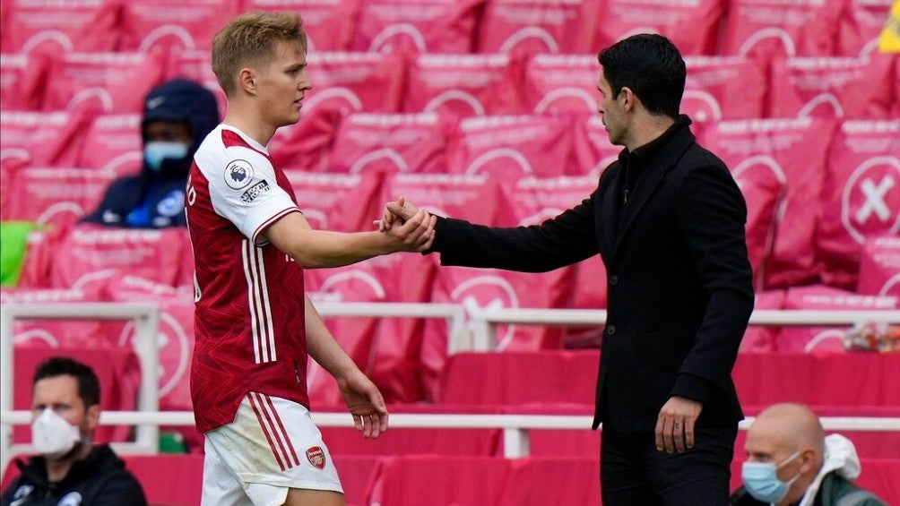 Martin Odegaard estrecha la mano de Mikel Arteta