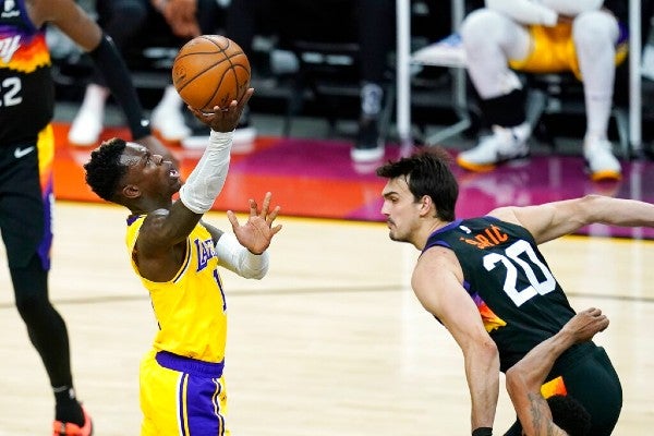 Dennis Schroder de los Lakers pasa sobre Dario Saric de los Suns