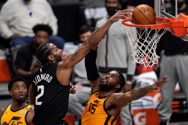 Kawhi Leonard hace una clavada por encima de Derrick Favors