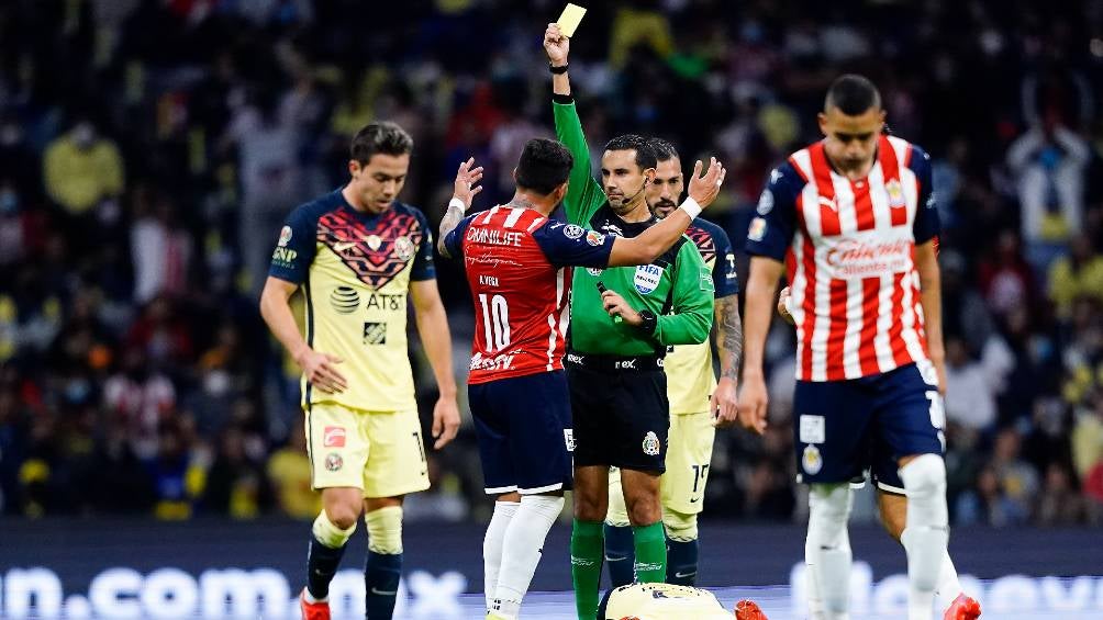 César Ramos mostrando una tarjeta en el Clásico Nacional