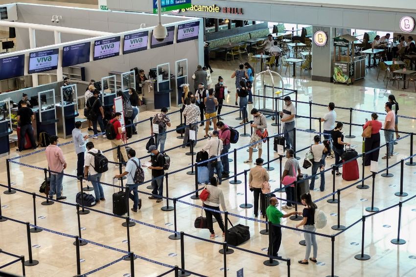 Personas formadas en el aeropuerto de Cancún