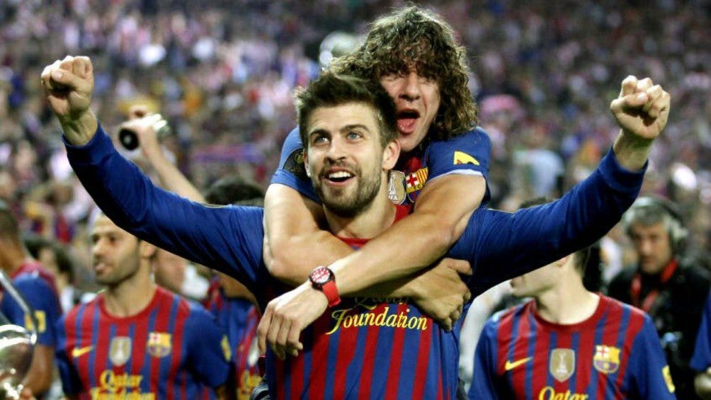 Carles Puyol abraza a Gerard Piqué durante la celebración de un título con el Barcelona