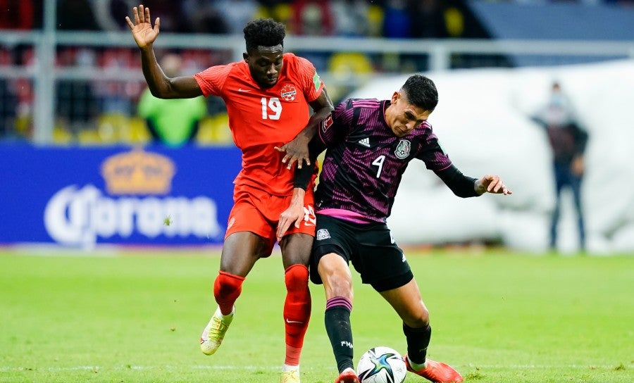 Alphonso pelea el balón con Edson Álvarez