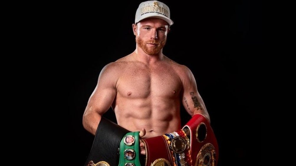 Canelo Álvarez posa con sus cinturones