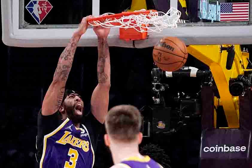 Anthony Davis, clavando el balón en la canasta en un partido 