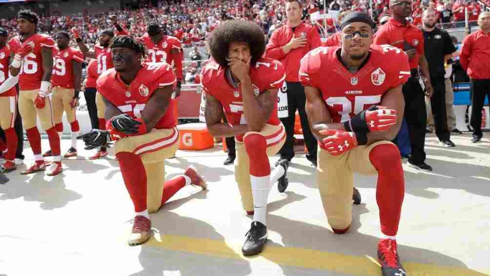 Kaepernick arrodillado en el himno estadounidense en forma de protesta