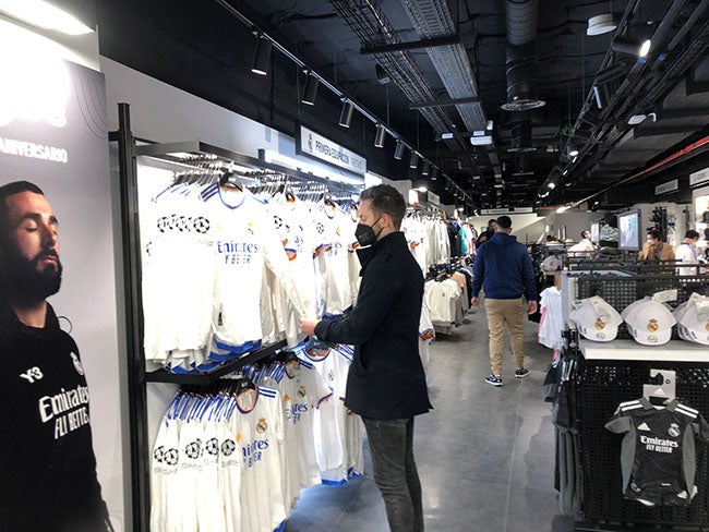 Afición observa los los productos oficiales en la tienda 