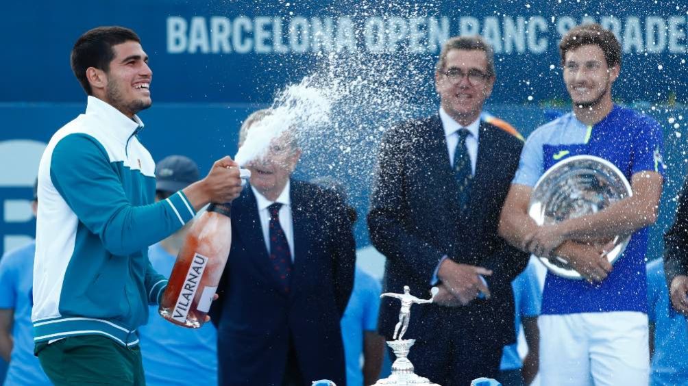 Carlos Alcaraz celebra con una botella de champán tras ganar el torneo de Barcelona de la ATP