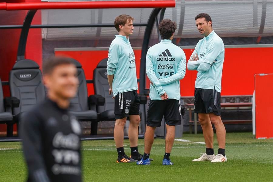 Scaloni platicando con su cuerpo técnico