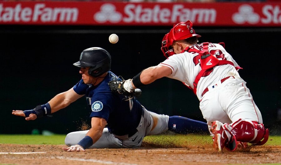 Dylan Moore se barre en home para la carrera de los Mariners