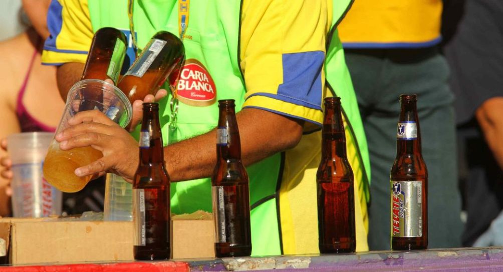 Persona sirviendo una cerveza en un estadio