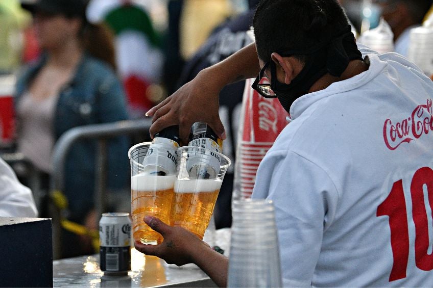 Persona sirviendo una cerveza en un estadio