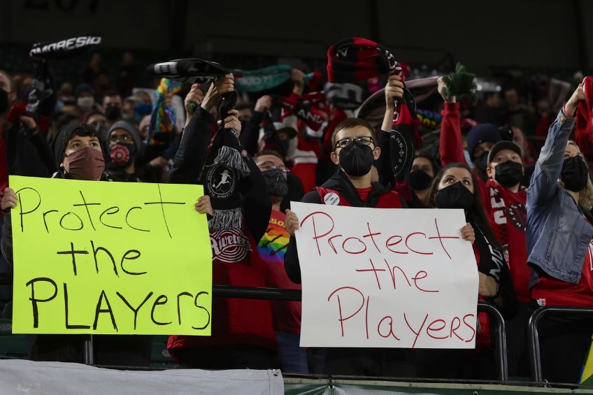 Fanáticos con carteles en un partido del futbol femenil estadounidense