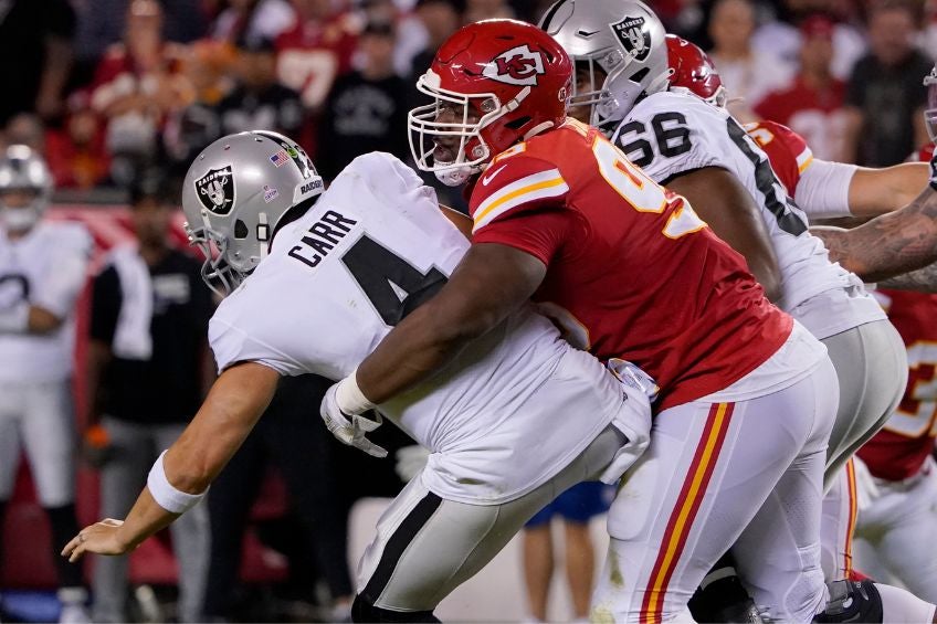 Chris Jones y Derek Carr durante un partido