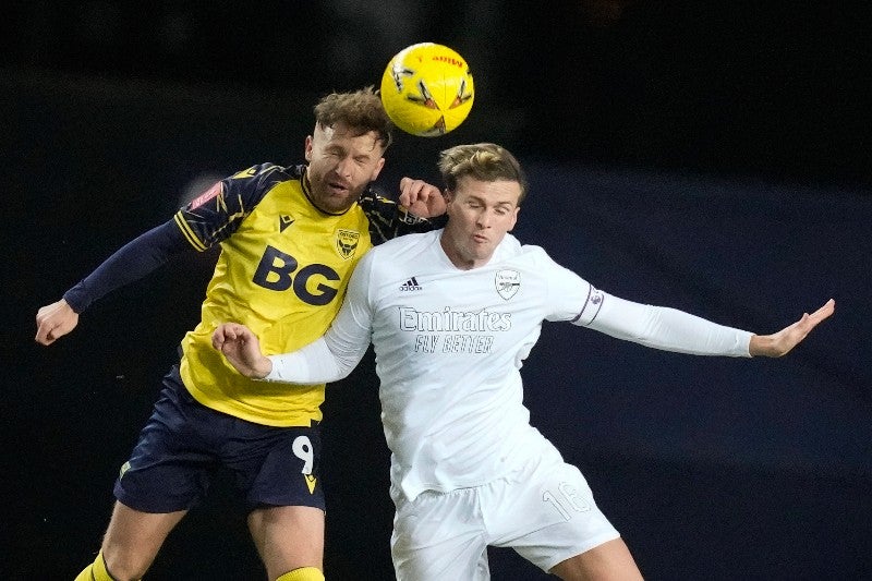 Matty Taylor y Rob Holding en disputa por el balón