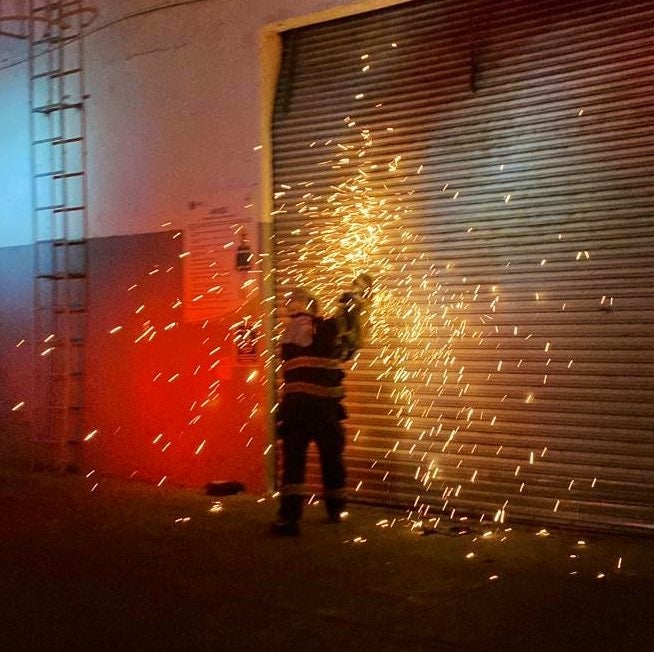 Bomberos abriendo la bodega donde comenzó el siniestro