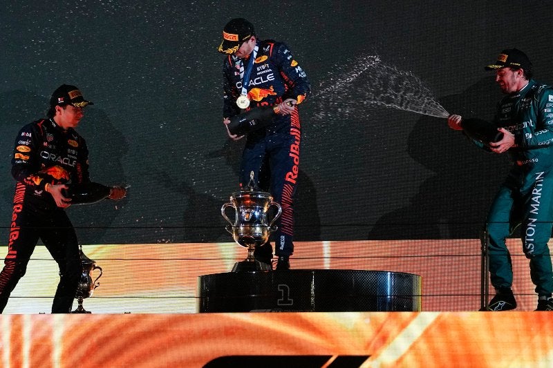 Checo, Max y Leclerc festejando podio