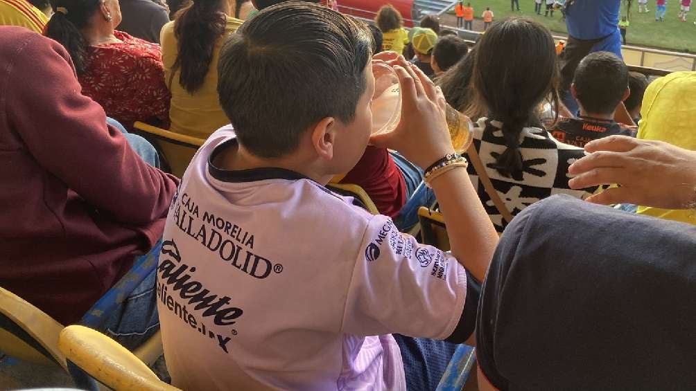 Niño bebiendo cerveza en el estadio Morelos