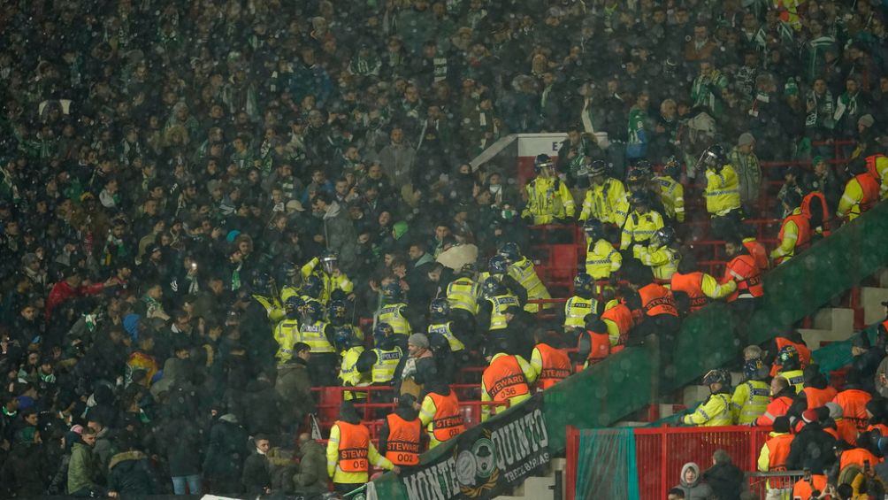 Seguidores del Betis se enfrentan a la policía durante un partido ante el Manchester United en Old Trafford, el jueves 9 de marzo de 2023 (AP Foto/Dave Thompson)