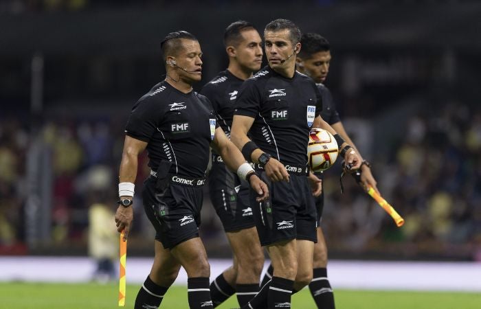 Fernando Hernández y el cuerpo arbitral en el partido entre América y León