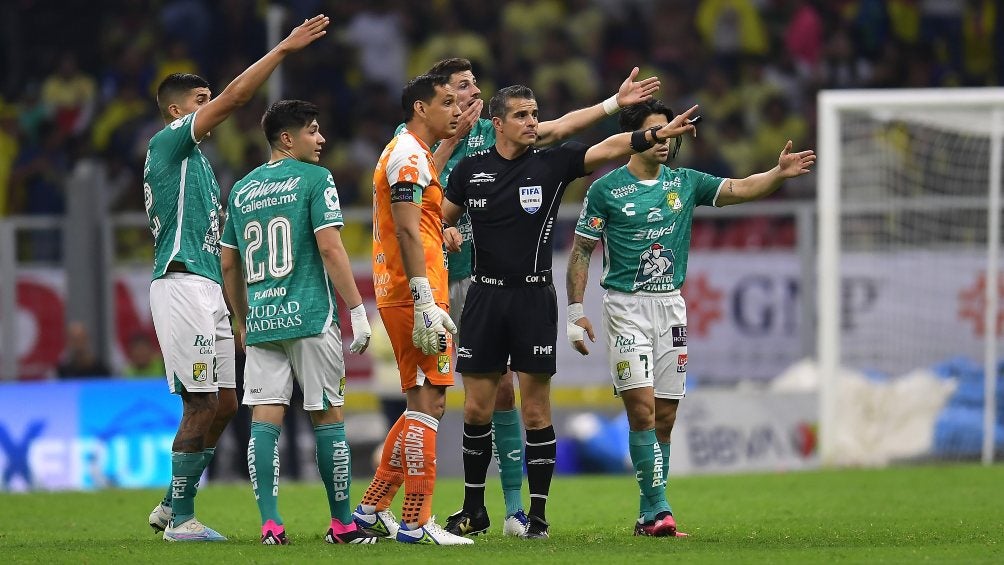 Fernando Hernández y jugadores del León señalan hacia la banda