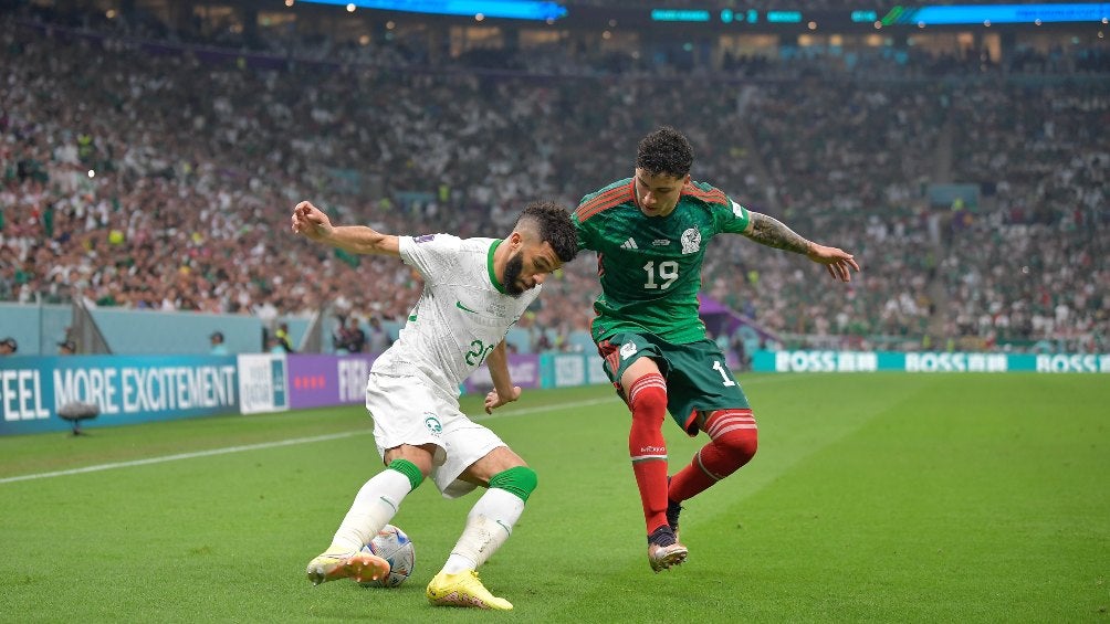 El mexicano intenta quitarle el balón a un jugador de Arabia Saudita