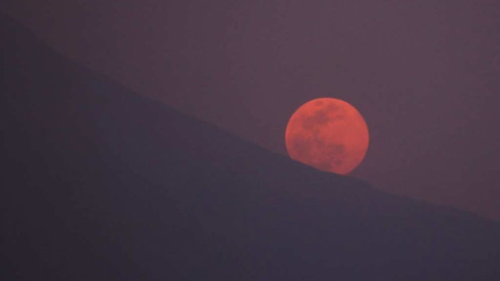 La luna hace su aparición detrás de las montañas