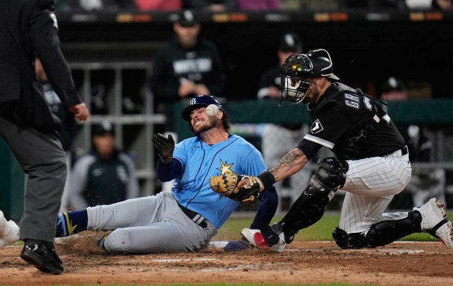 Josh Lowe es golpeado por la bola al llegar a home