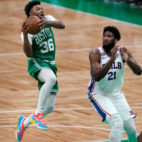 Marcus Smart intentando una canasta ante Joel Embiid