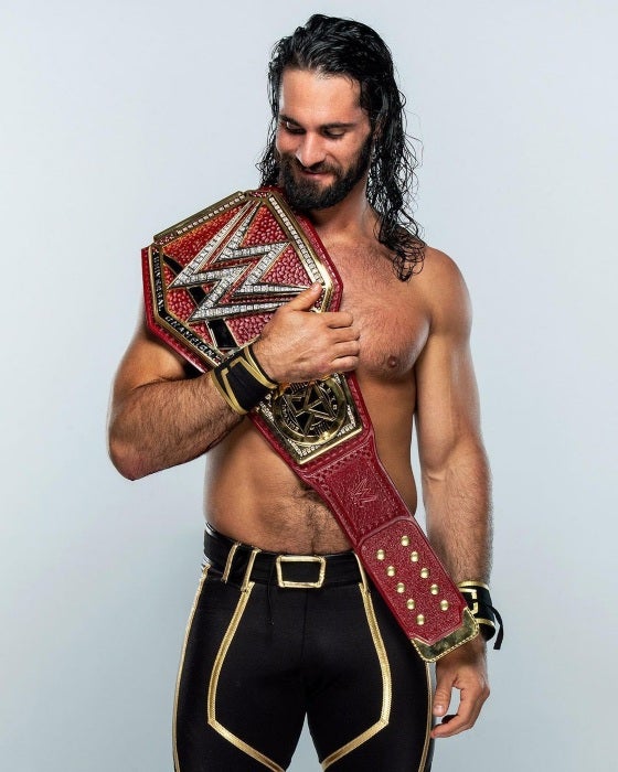 Seth Rollins con otro de sus cinturones en la sesión de fotos