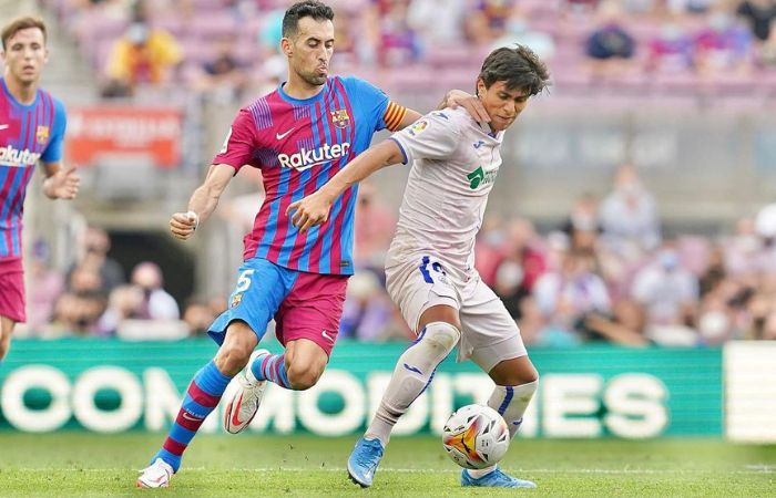 JJ Macías y Sergio Busquets disputando un balón