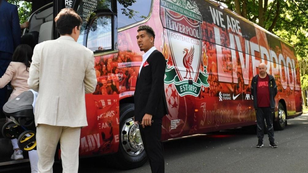 Firmino parado al lado del camión del equipo