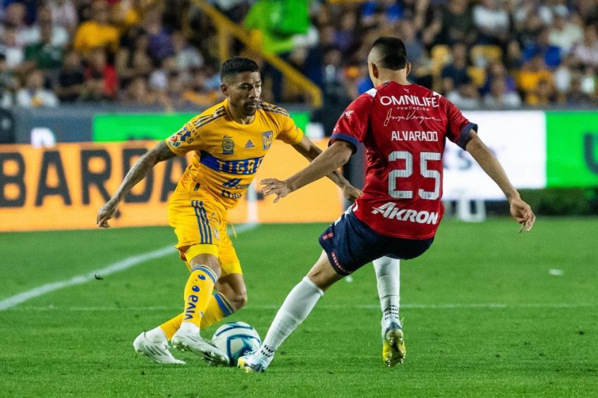 Aquino y Alvarado luchan por la pelota en el Tigres vs Chivas