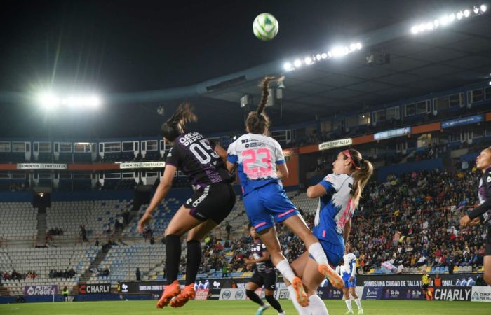 Jugadoras de Tuzos y Rayadas disputando un balón aéreo