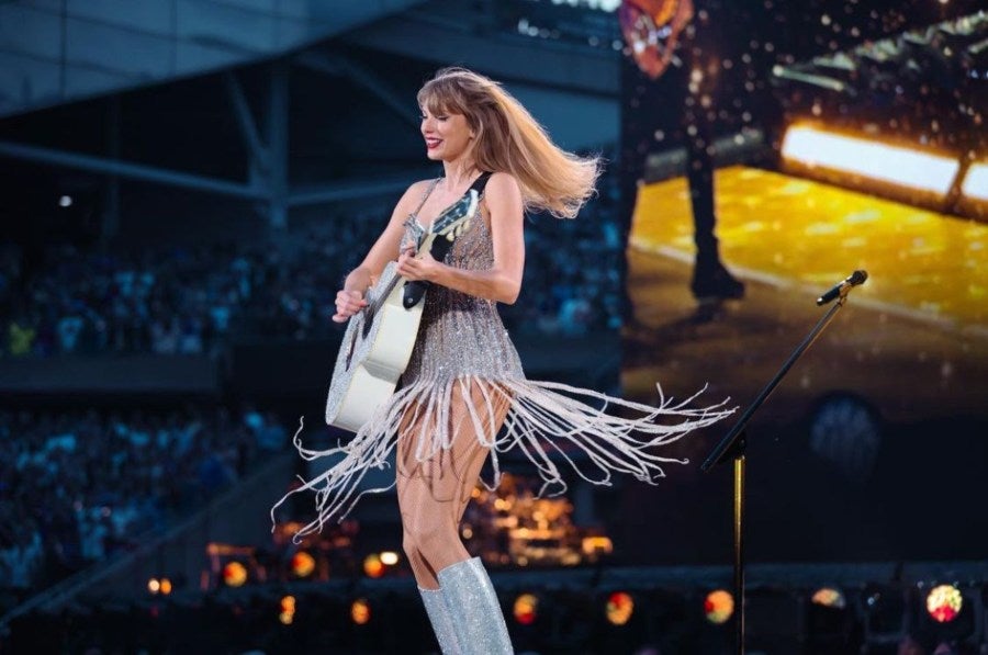 Taylor Swift tocando la guitarra en concierto