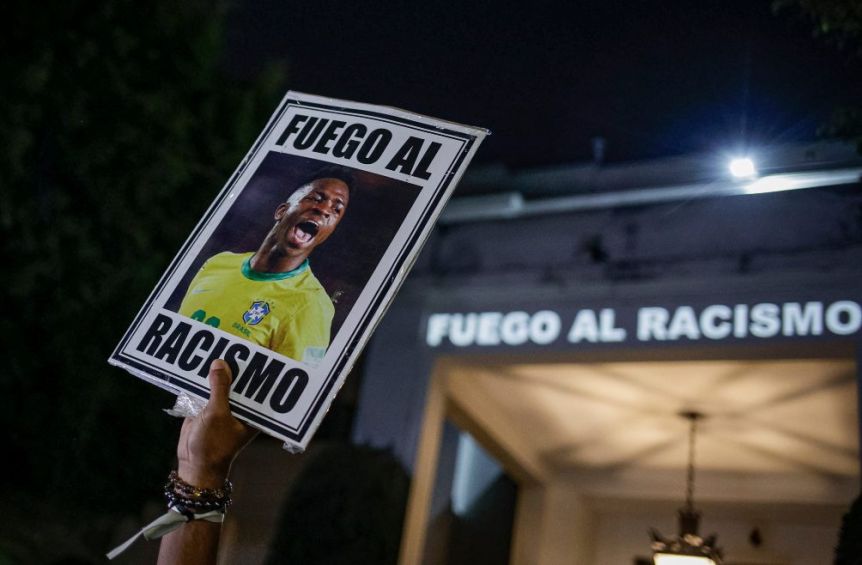 Manifestante sostiene una imagen del futbolista brasileño Vinicius Junior