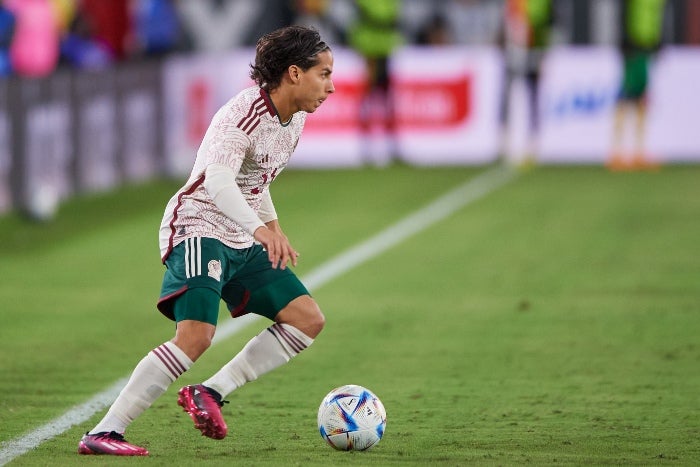 Lainez conduce la pelota en un partido de México